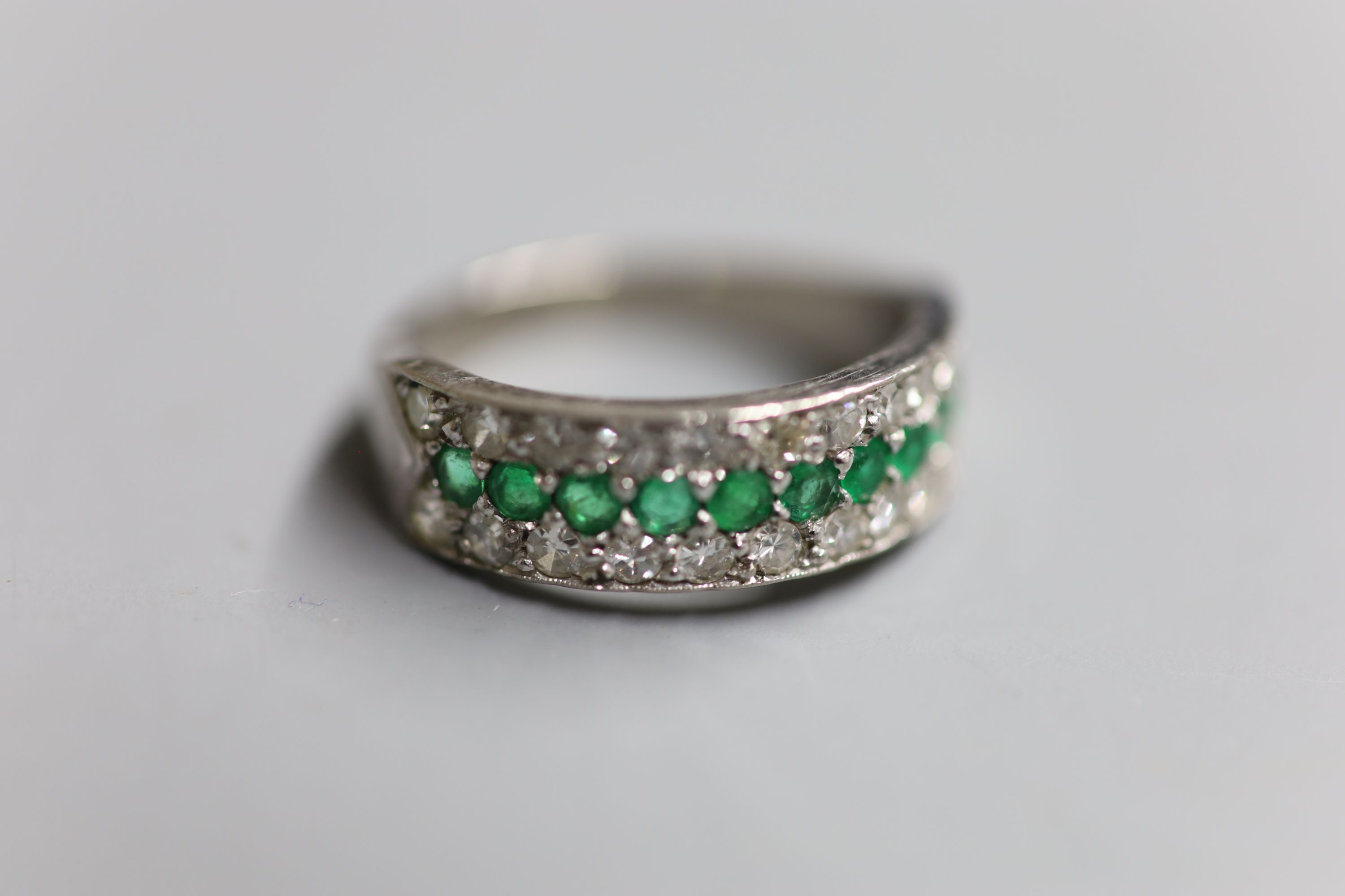 A modern 18ct white metal, emerald and diamond three row half hoop ring, size Q, gross 6.7 grams.